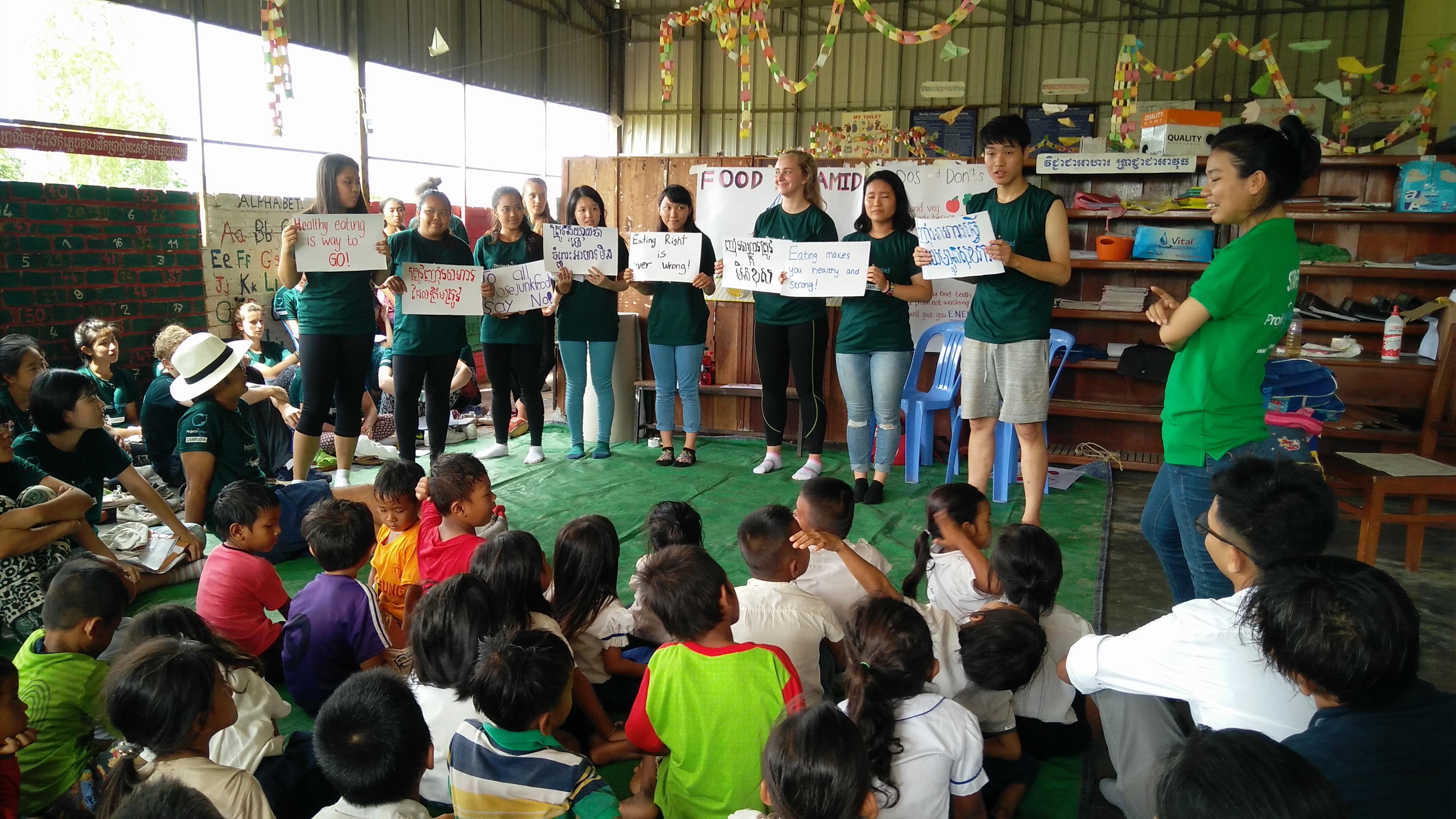 Students on the Projects Abroad Public Health Internship for teenagers in Cambodia, teach children in a school about healthy eating. Interns run a healthy eating campaign as part of their Public Health work for teenagers in Cambodia.